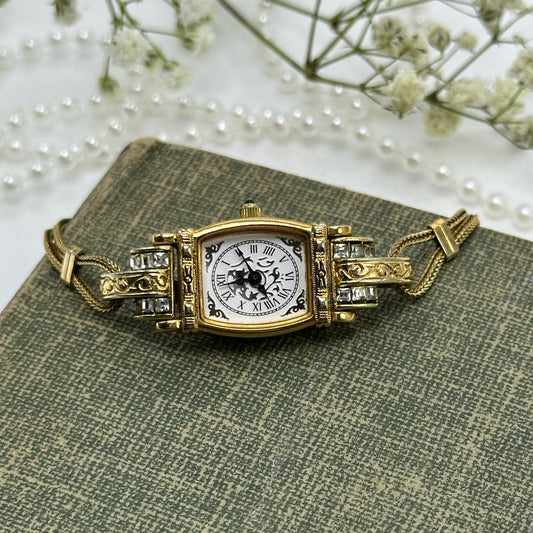 Elegant art deco style gold tone watch with diamanté stones and metal clasp band.