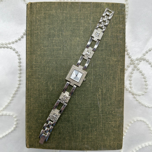 Elegant vintage silver tone watch with square dial and quartz movement.