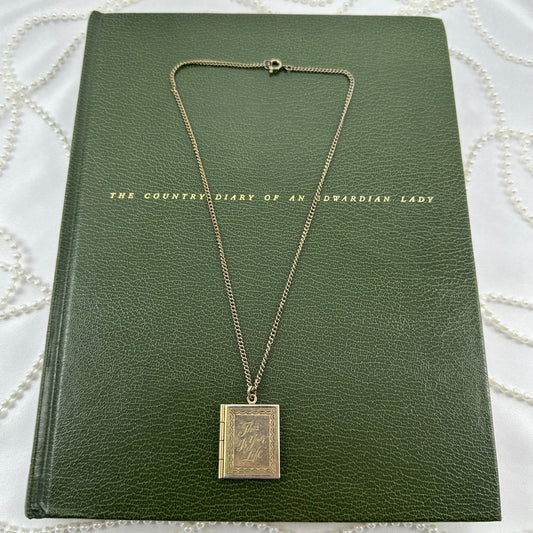 Gold tone book locket with "This is Your Life" engraved. Both sides can hold a photo.