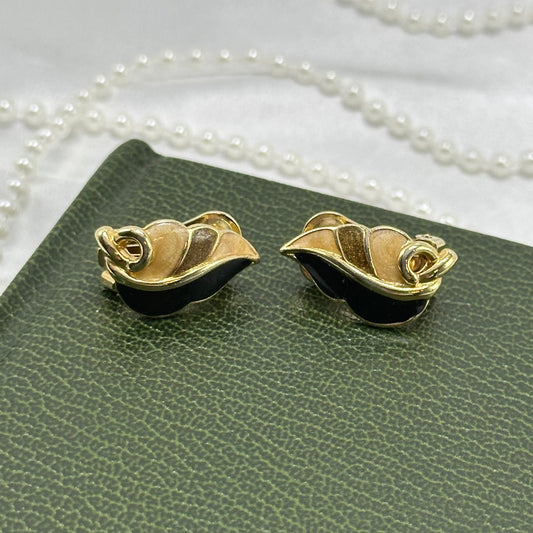 Vintage gold tone abstract leaf clip on earrings with black and tan enamel details.