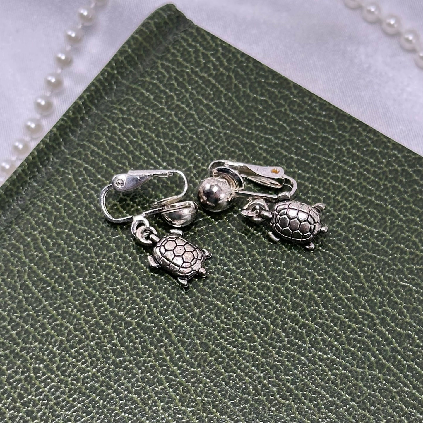 Dangle silver tone clip on turtle earrings.