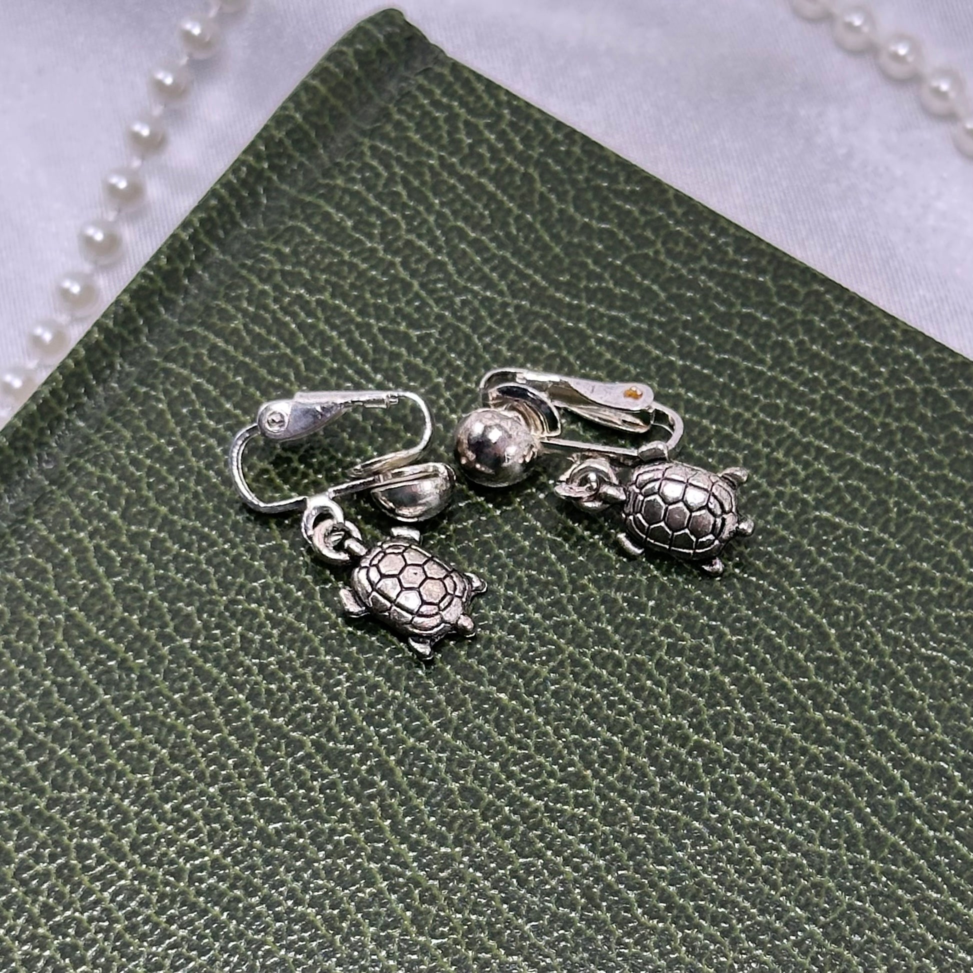 Dangle silver tone clip on turtle earrings.