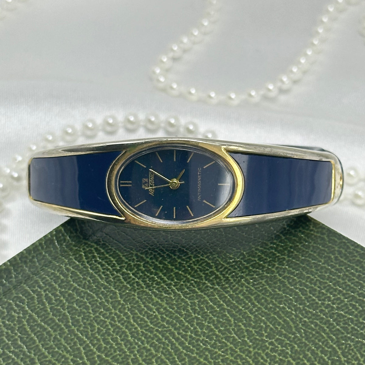 vintage navy blue and gold tone Nelsonic antimagnetic watch with oval dial and cuff/bangle band from the 1980's