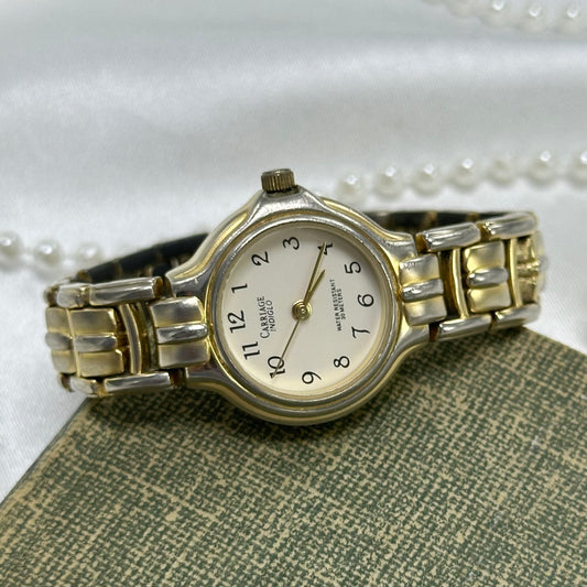 Gold and silver tone Carriage Indiglo watch with quartz movement. Water resistant (30M). Dial glows when crown is pushed in.