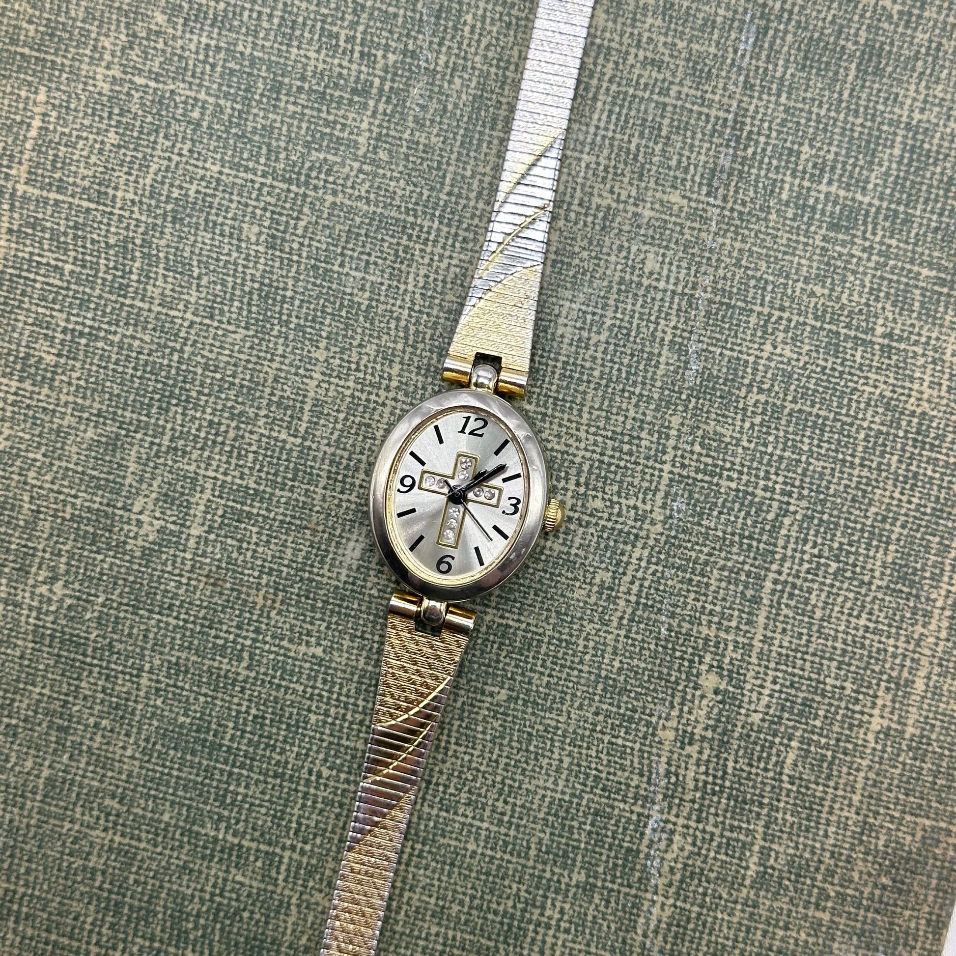 Gold and silver tone diamanté cross watch with quartz movement.