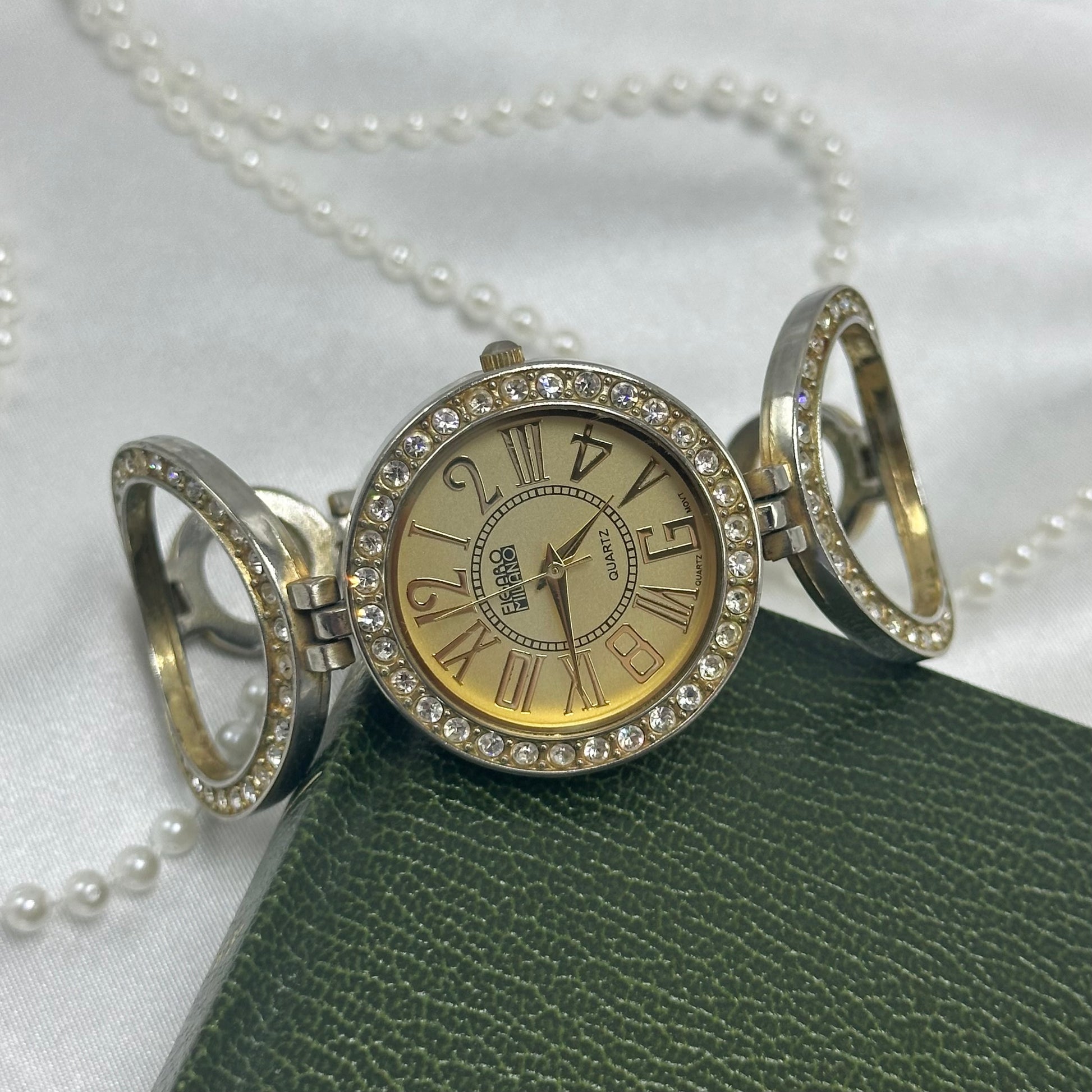 Gold tone Figaro Milano watch with large round diamanté dial and circle links.