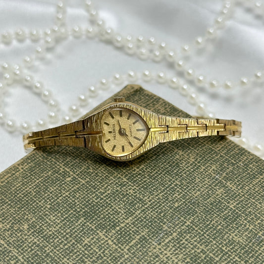 Gold tone Helbros heart watch with quartz movement.