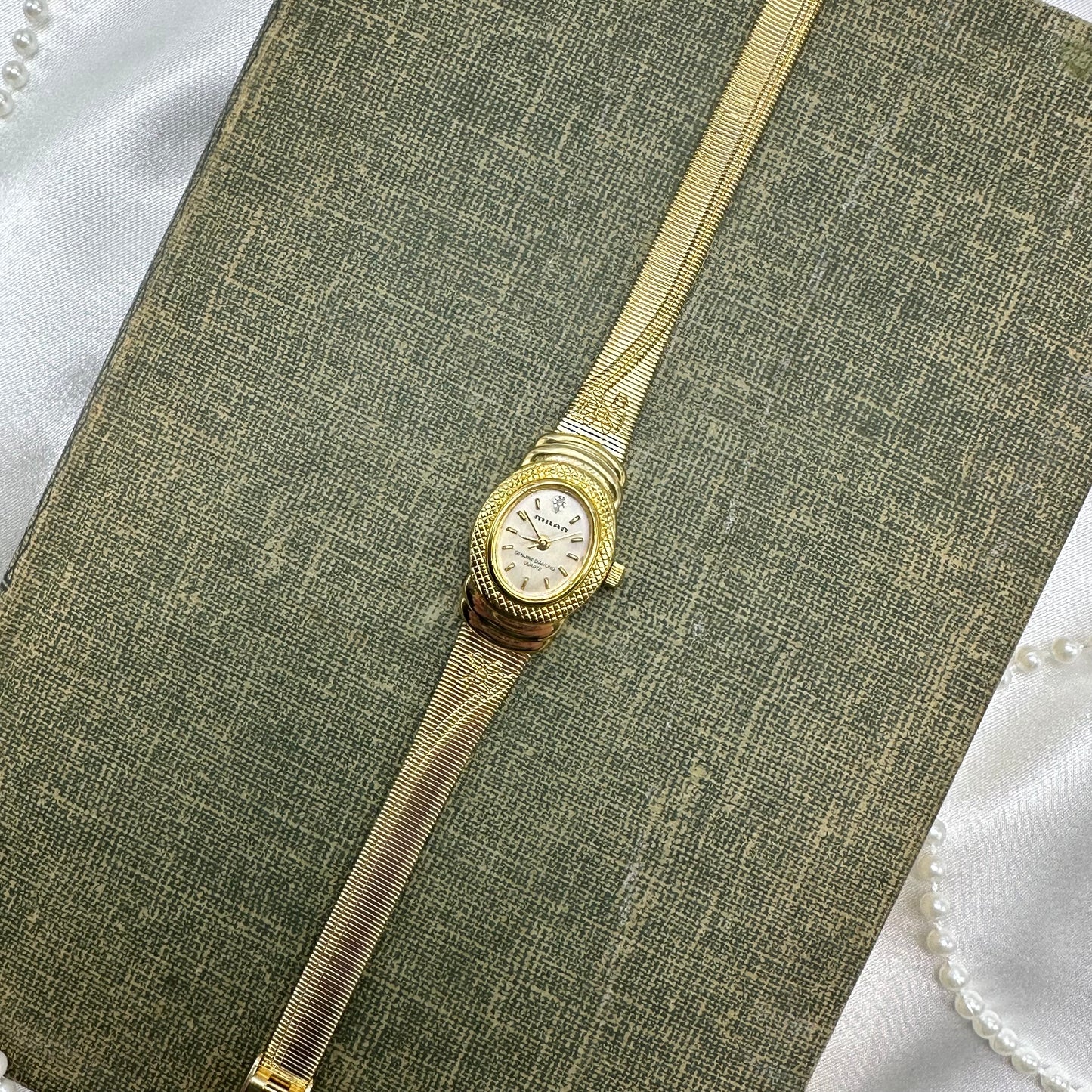 Gold tone Milan watch with cute bows on the band and genuine diamond quartz movement.