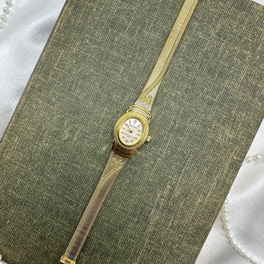 Gold tone Milan watch with cute bows on the band and genuine diamond quartz movement.