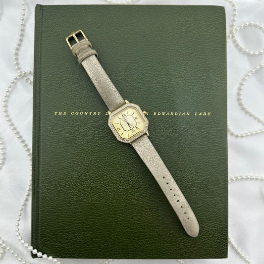 Gold tone Relic by Fossil watch with diamanté dial, date display, roman numeral markers and metallic leather band.