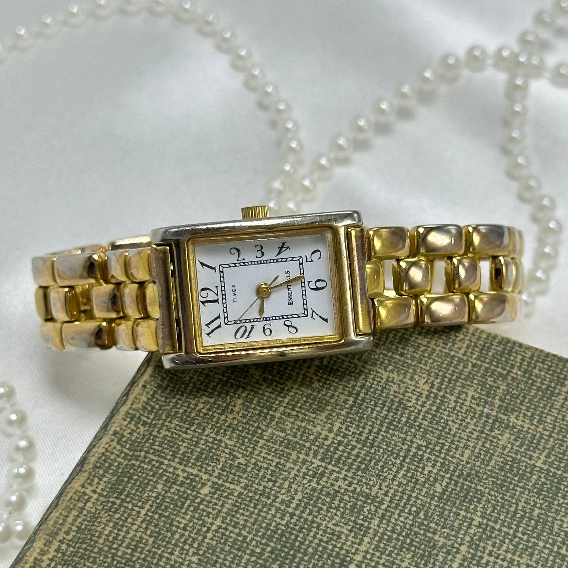 Gold tone Timex watch with rectangle dial and quartz movement.