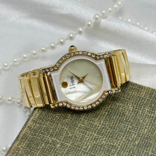 Gold tone Vivani watch with mother of pearl diamanté dial and stretchable band. Crown is a black jewel.