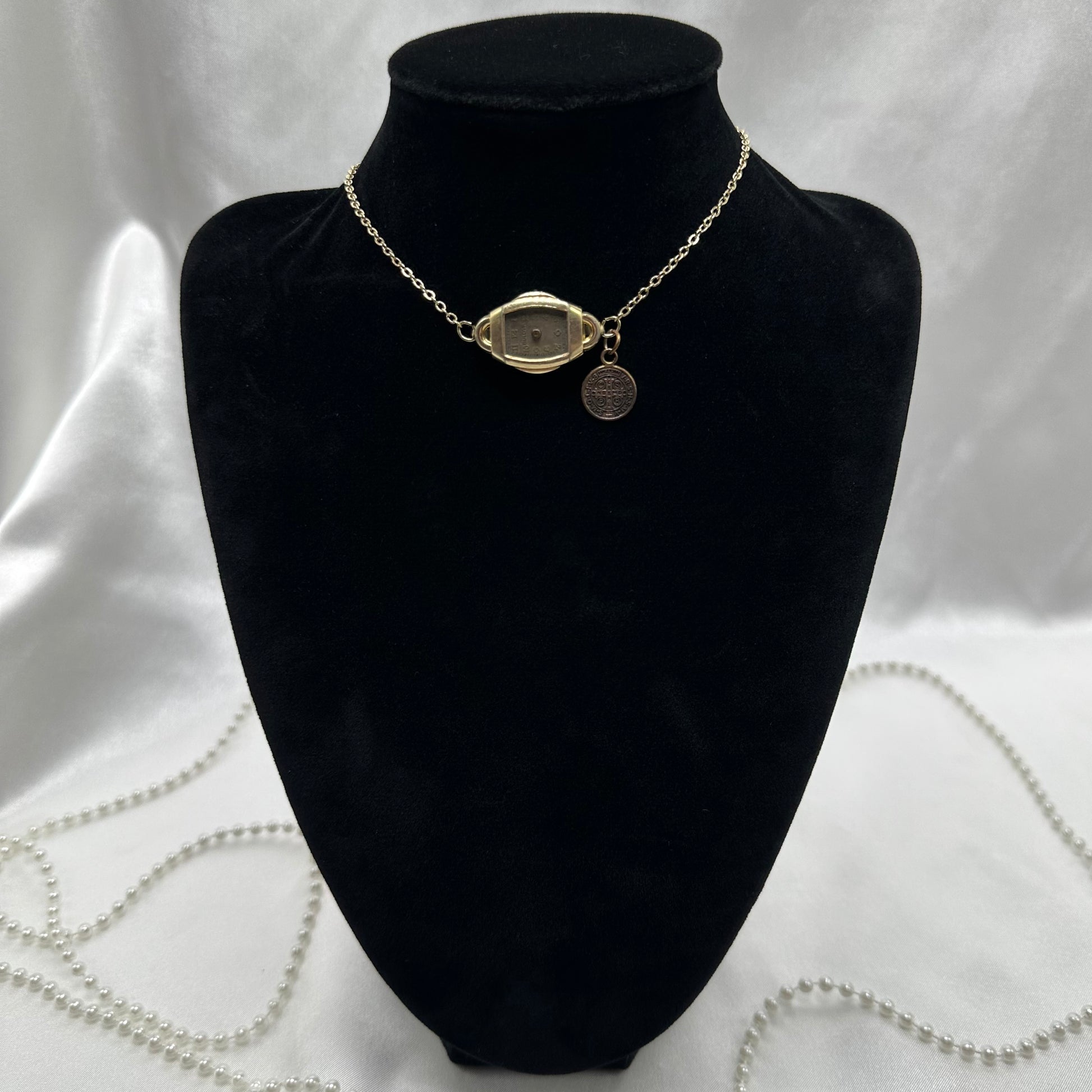 Gold tone choker necklace with vintage watch and Saint Benedict medal.