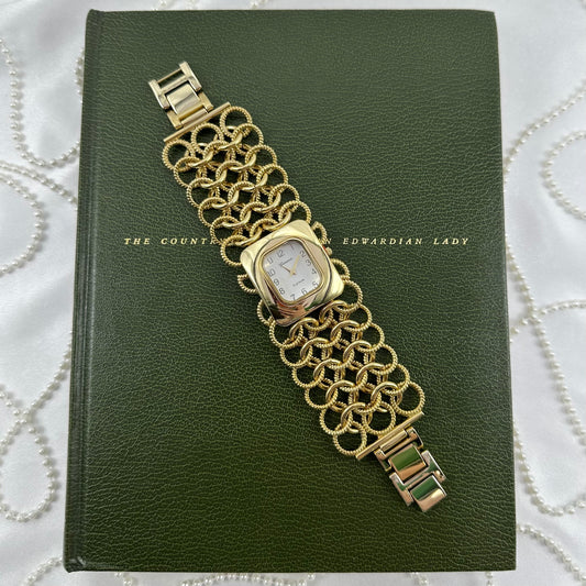 Gold tone chunky Geneva Platinum watch with square dial and connected chain ring band