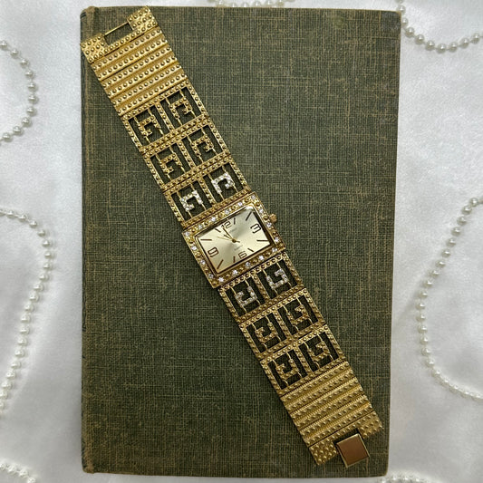Gold tone chunky diamante watch with quartz movement and elegant clasp band.