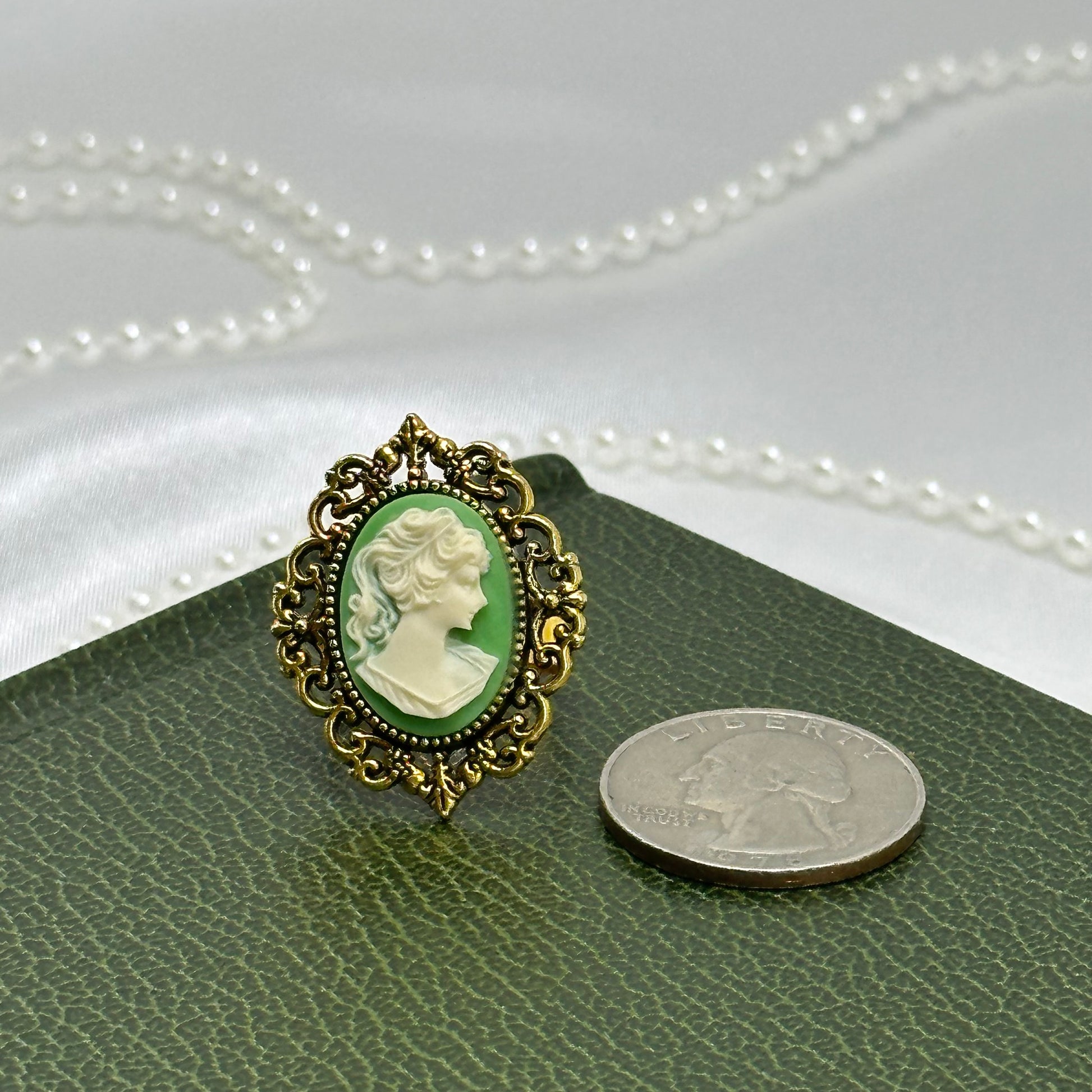 Gold tone large filigree ring with green cameo.
