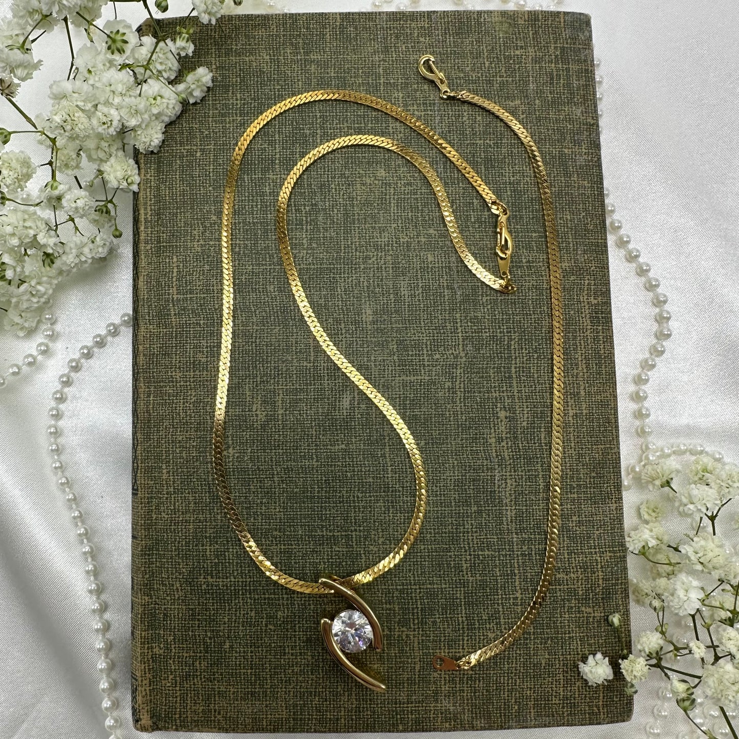 Gold tone necklace with sliding crystal pendant and matching bracelet.