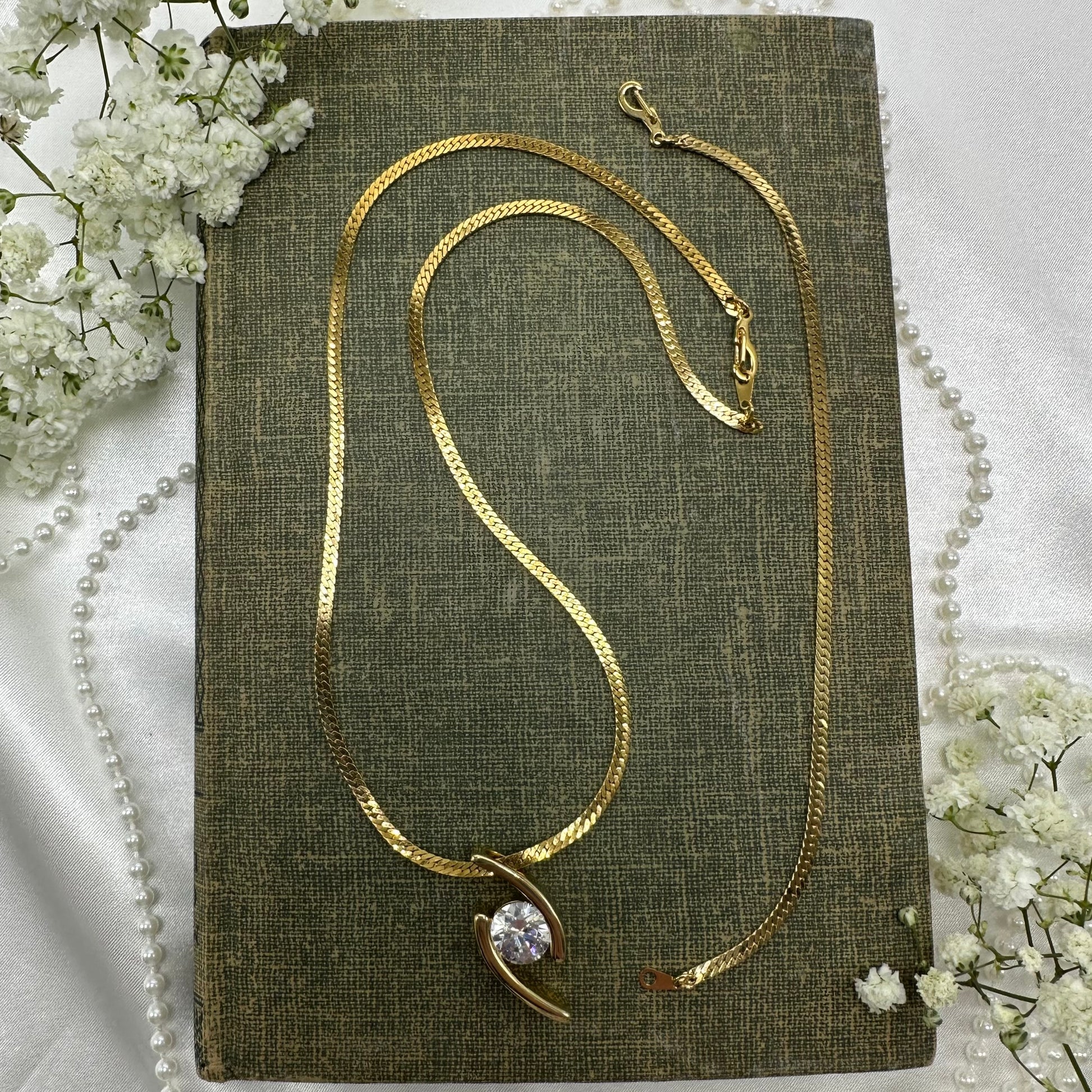 Gold tone necklace with sliding crystal pendant and matching bracelet.