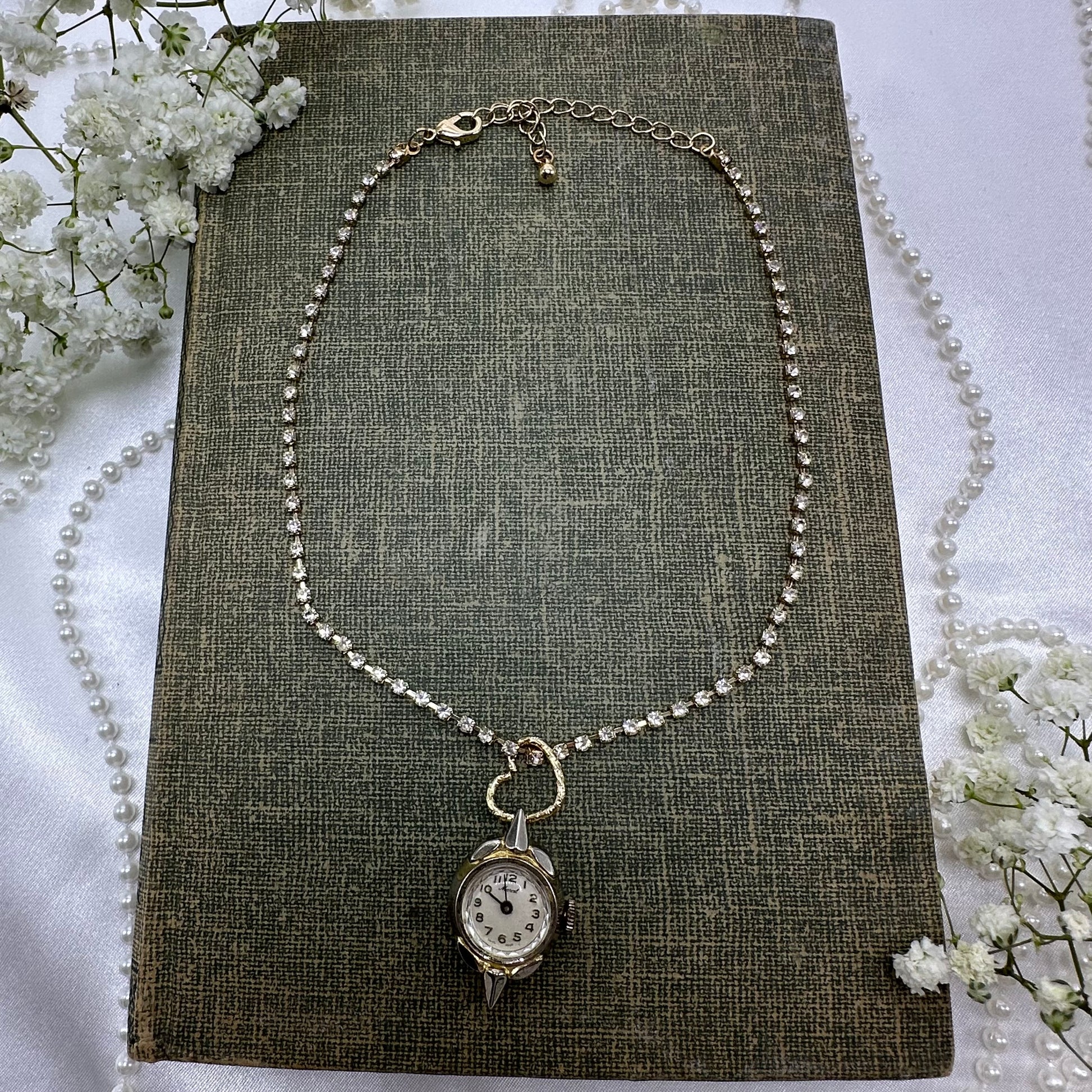 Gold tone rhinestone necklace with heart bail and vintage watch pendant.