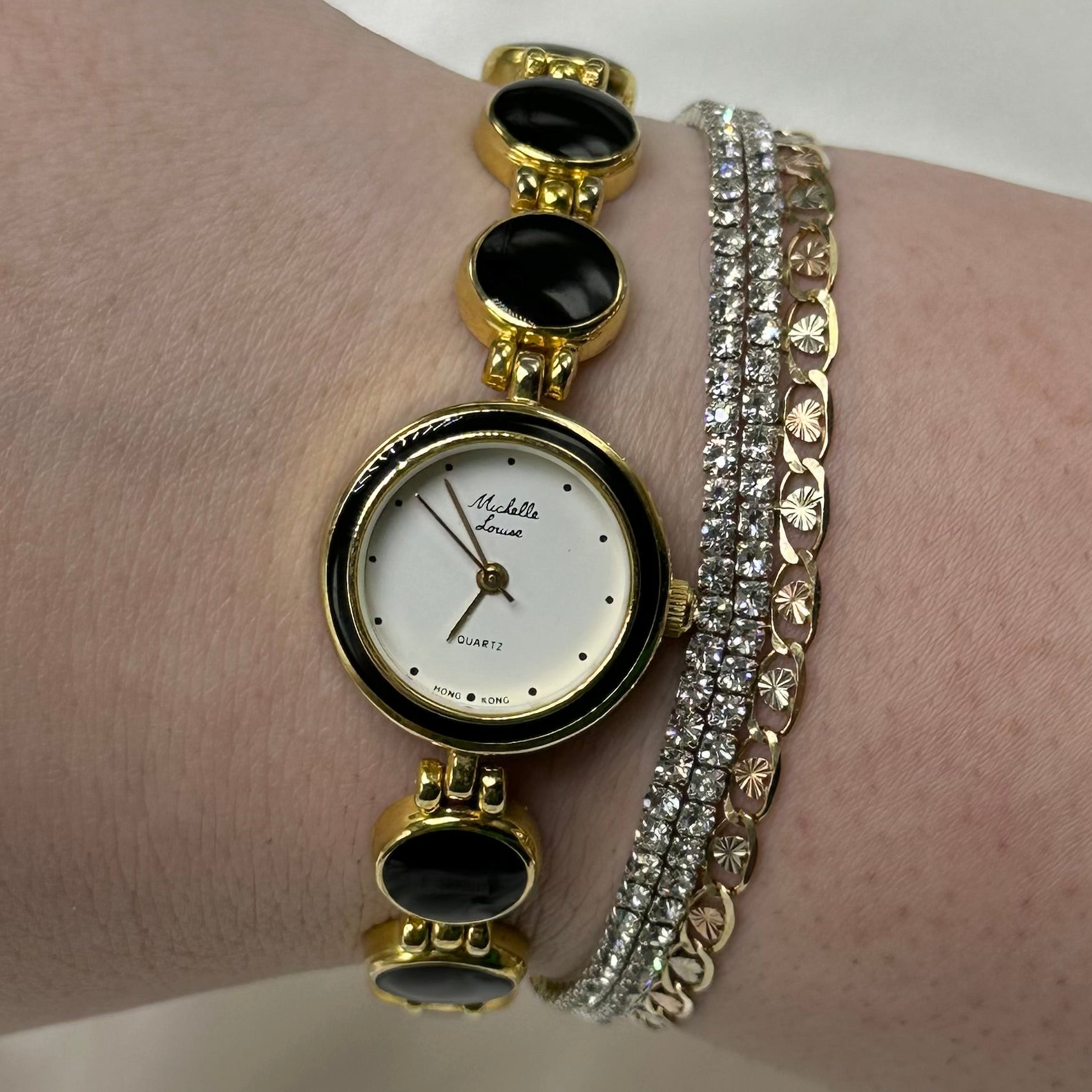 Gold tone round dial watch with quartz movement and clasp band