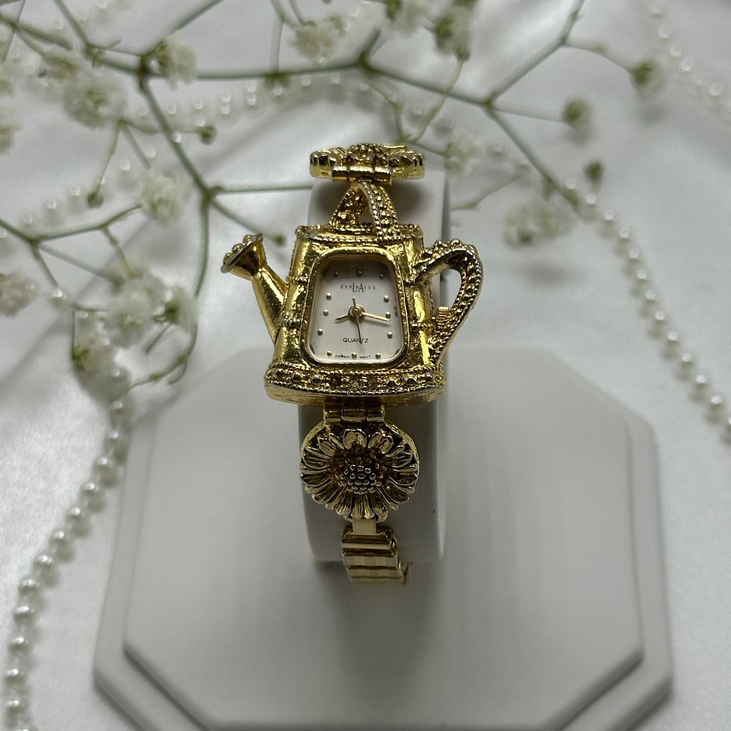 Gold tone sunflowers and watering can LA Express watch with quartz movement and stretchable band.