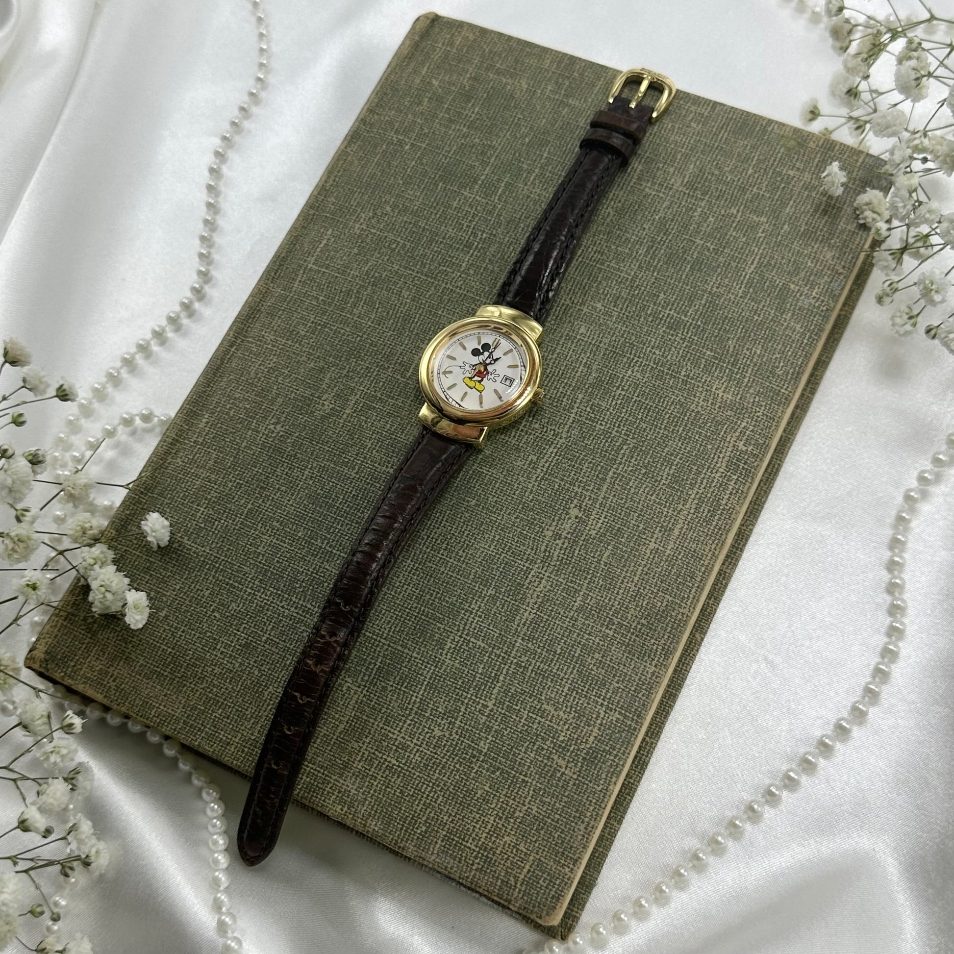 Gold tone vintage Disney watch with quartz movement and original Disney band.