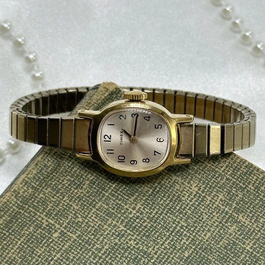 Gold tone vintage Timex mechanical winding watch with stretchable band.