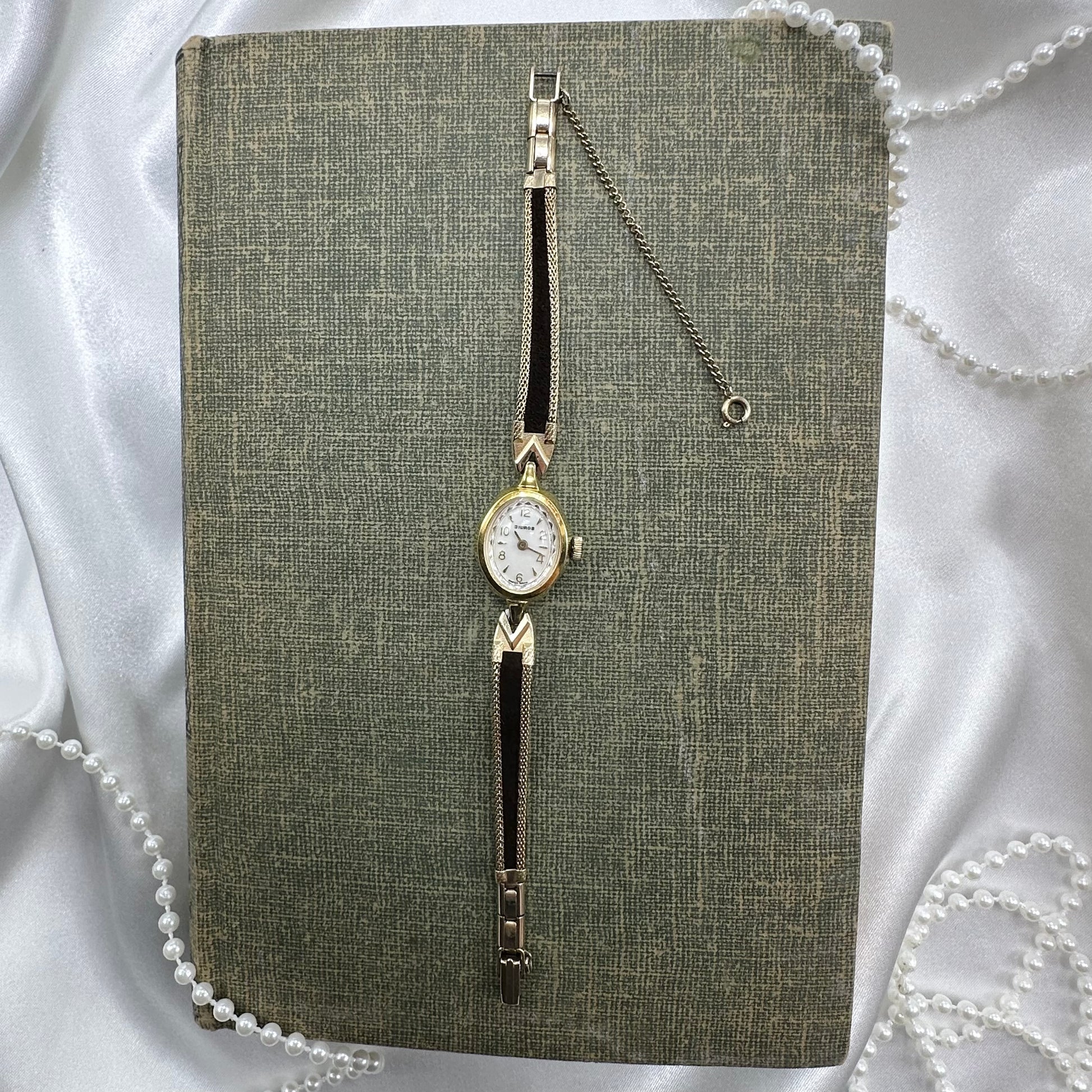 Gold tone watch with black velvet band.