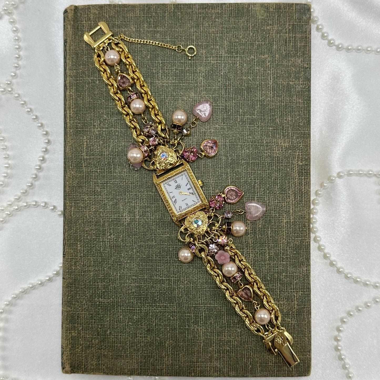Rare vintage gold tone Kirk's Folly watch with pink heart and pearl charms.