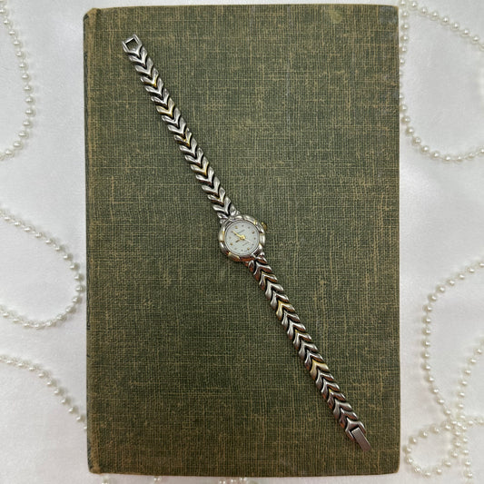 Silver and gold tone round dial Rumours watch with unique metal band and quartz movement.