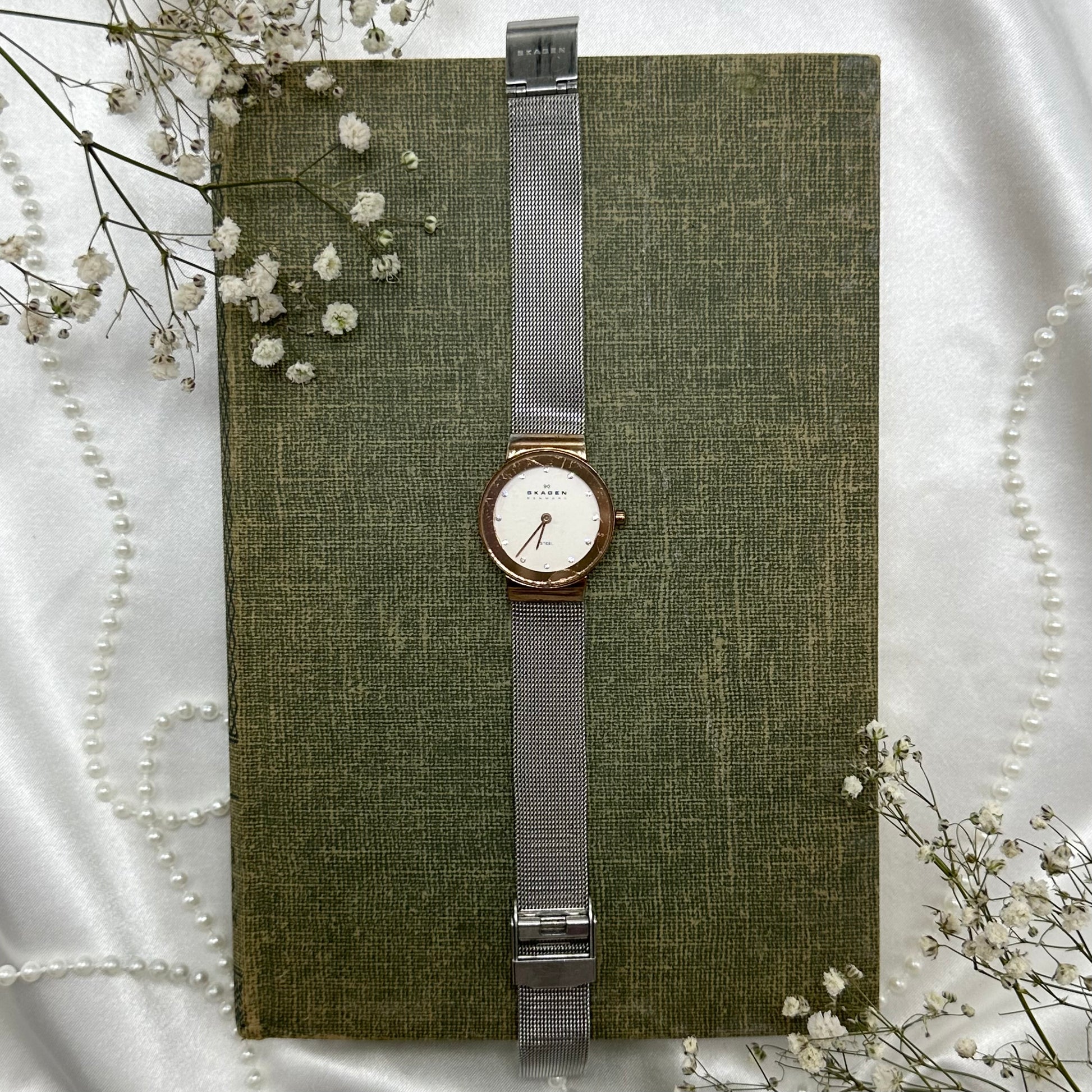 Silver and rose gold tone Skagen Denmark watch with clasp band.