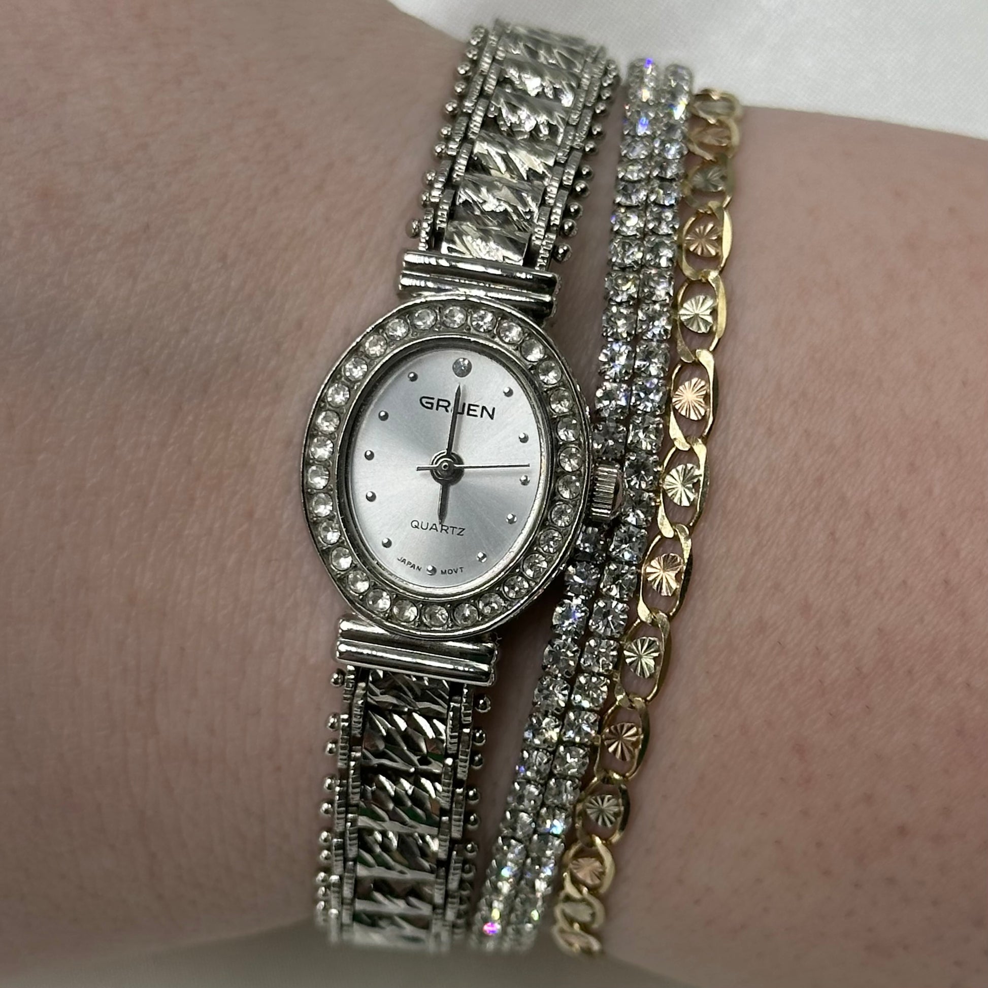 Silver diamanté Gruen oval dial watch with quartz movement and unique bracelet band.