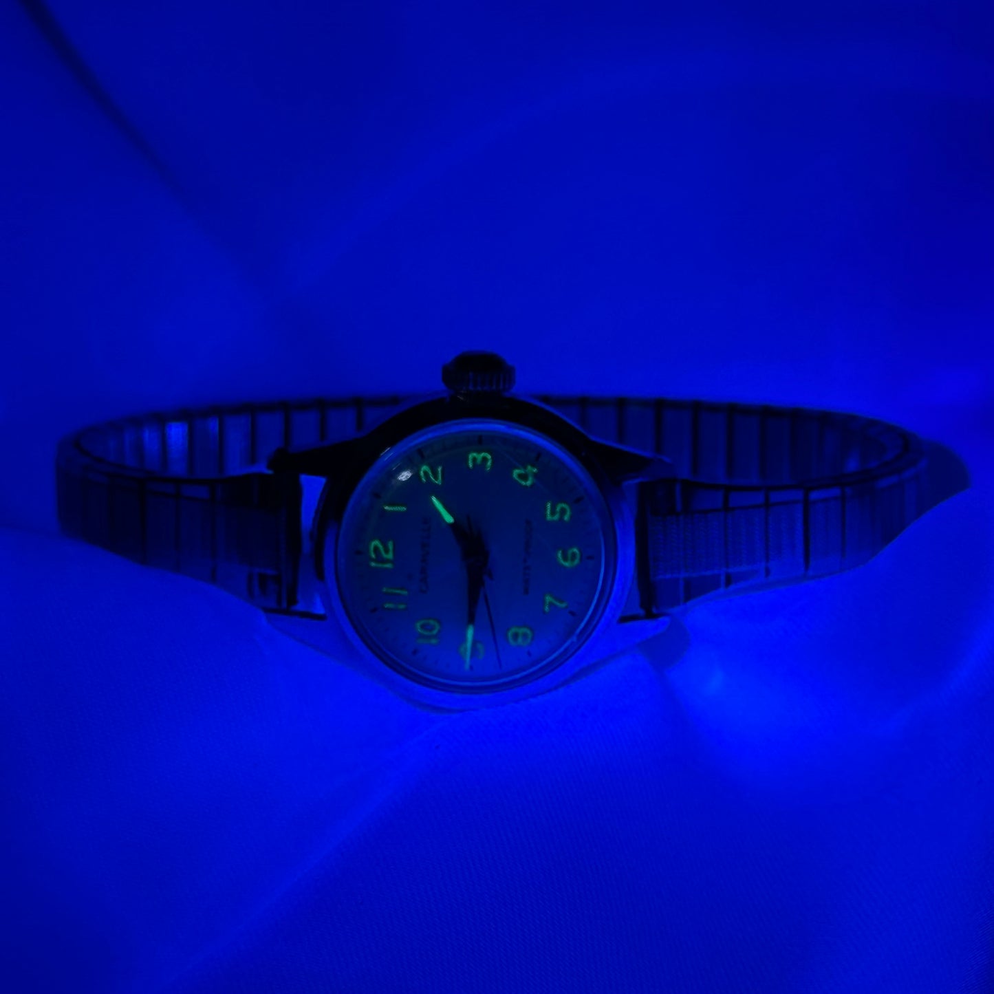 Silver tone Caravelle waterproof manual winding watch with stretchable band and glow in the dark dial from 1968