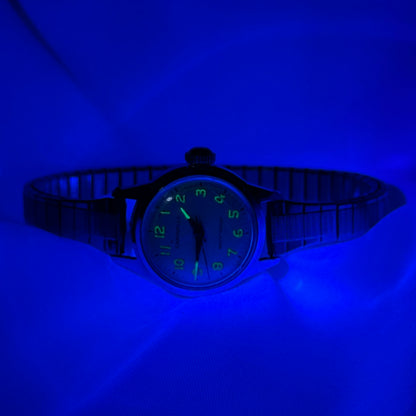 Silver tone Caravelle waterproof manual winding watch with stretchable band and glow in the dark dial from 1968