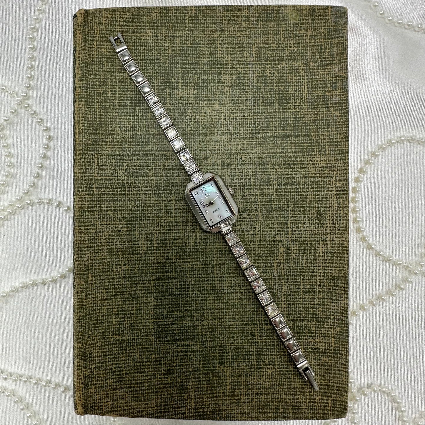 Silver tone GEORGE watch with rectangle mother of pearl dial and quartz movement.