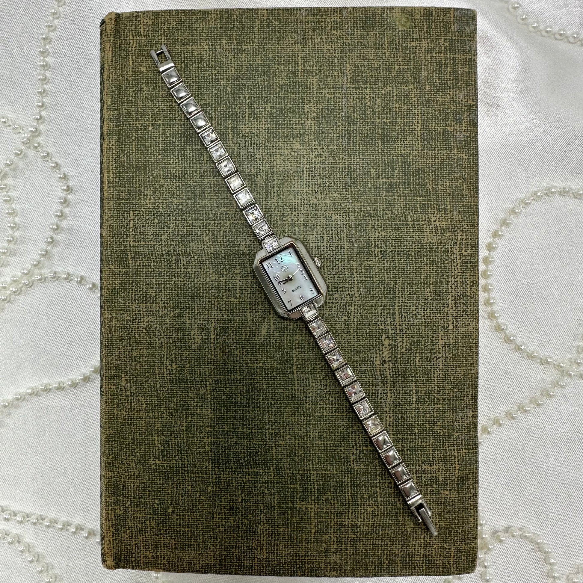 Silver tone GEORGE watch with rectangle mother of pearl dial and quartz movement.