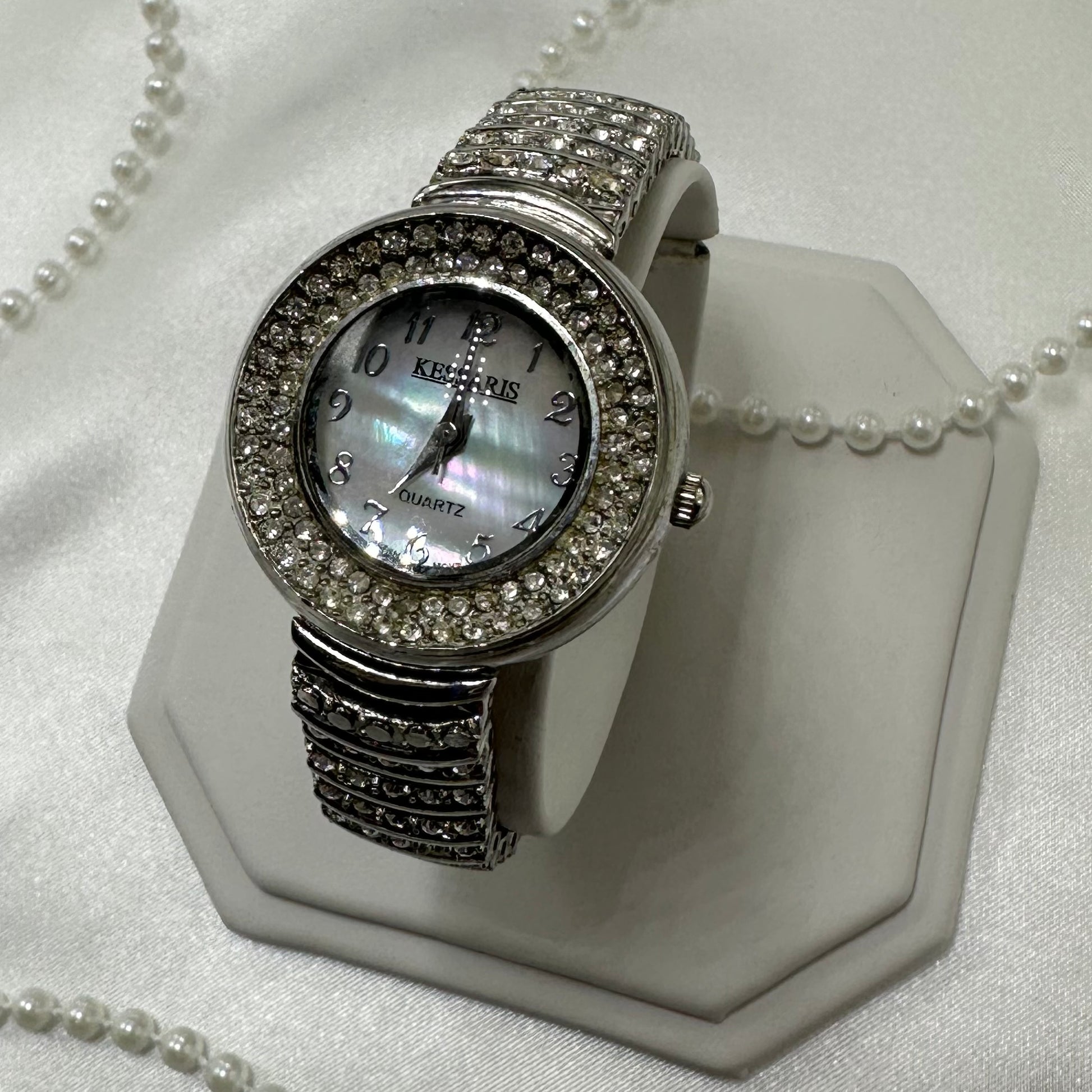 Silver tone diamanté watch with quartz movement and clasp band.