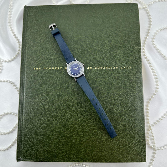Silver tone manual winding Timex watch with dark blue round dial and dark blue band from the 1970's.