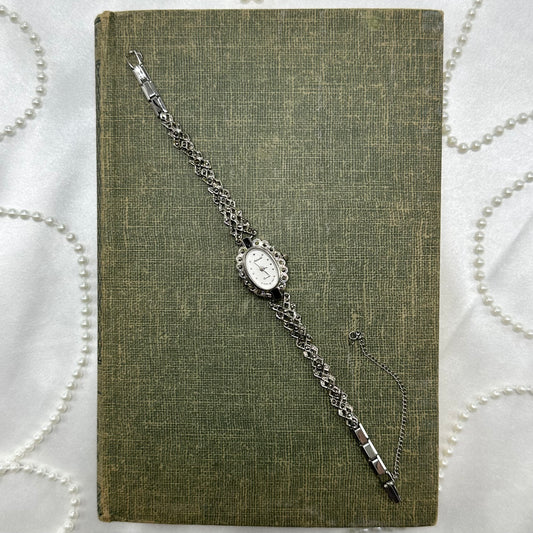 Silver tone marcasite Notsuko watch with quartz movement and safety clasp.