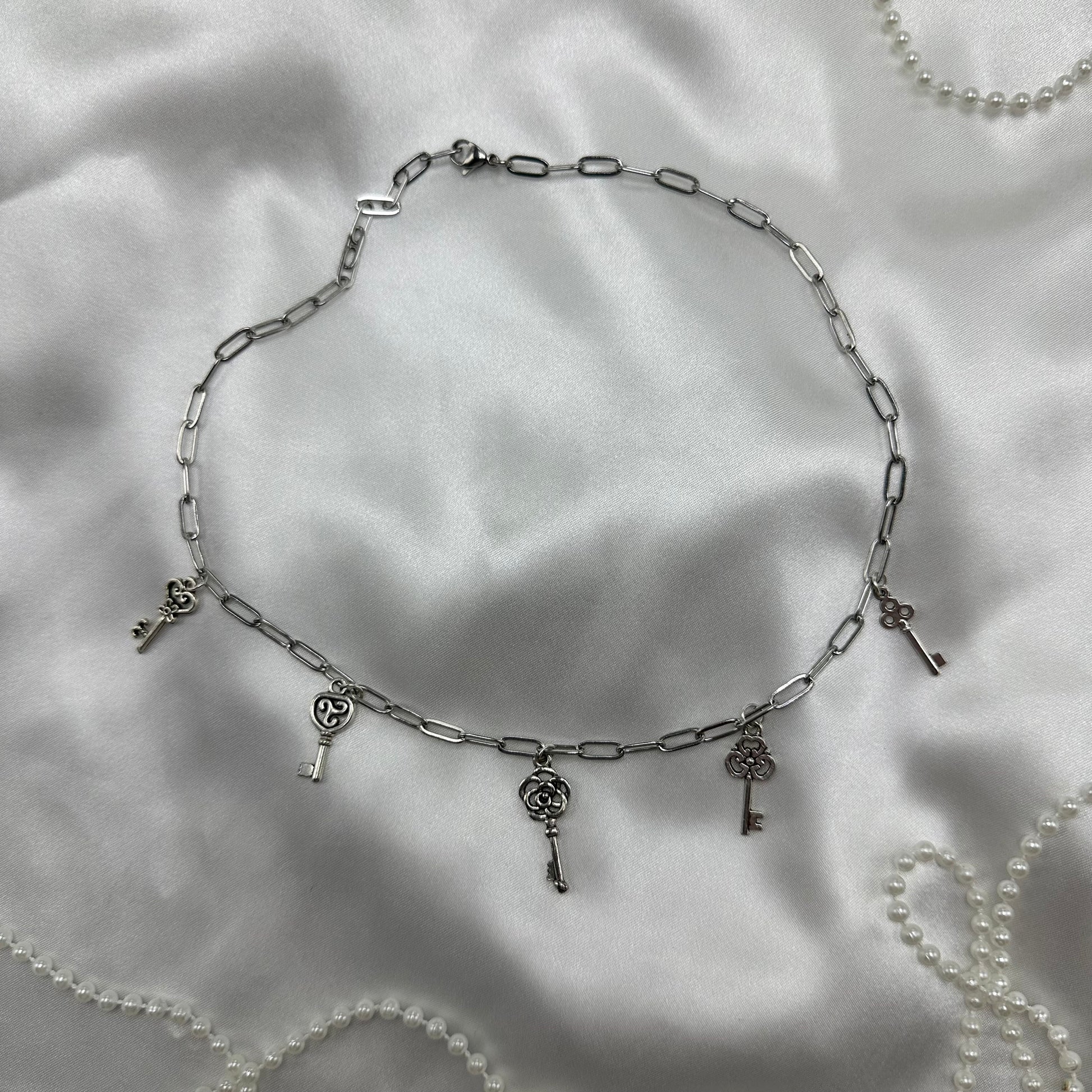 Silver tone paperclip chain necklace with vintage style skeleton key charms. Nickle free stainless steel chain.