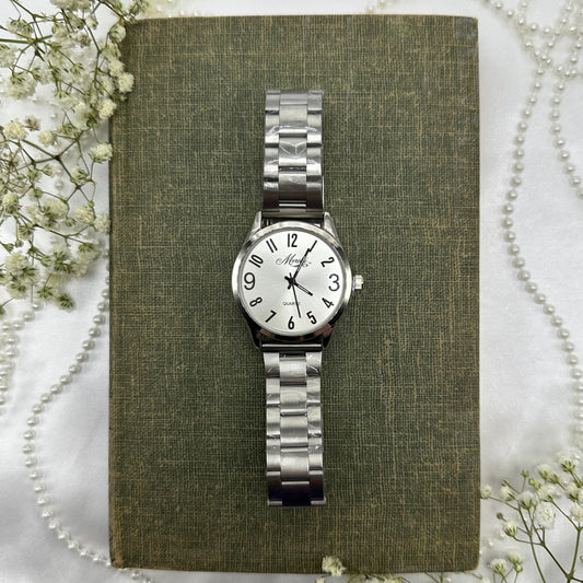Silver tone round dial Moretti watch with quartz movement and thick clasp band. Band still has original plastic coverings and the plastic was never removed from the crown