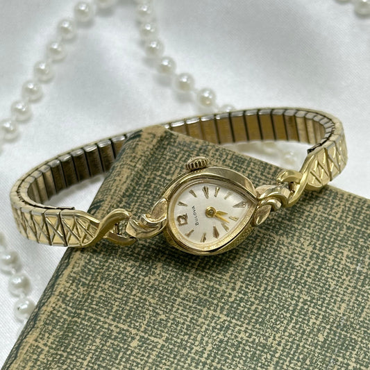 Vintage 10k rolled gold plated manual winding Bulova watch from the 1960's with stretchable detailed band and unique teardrop dial.