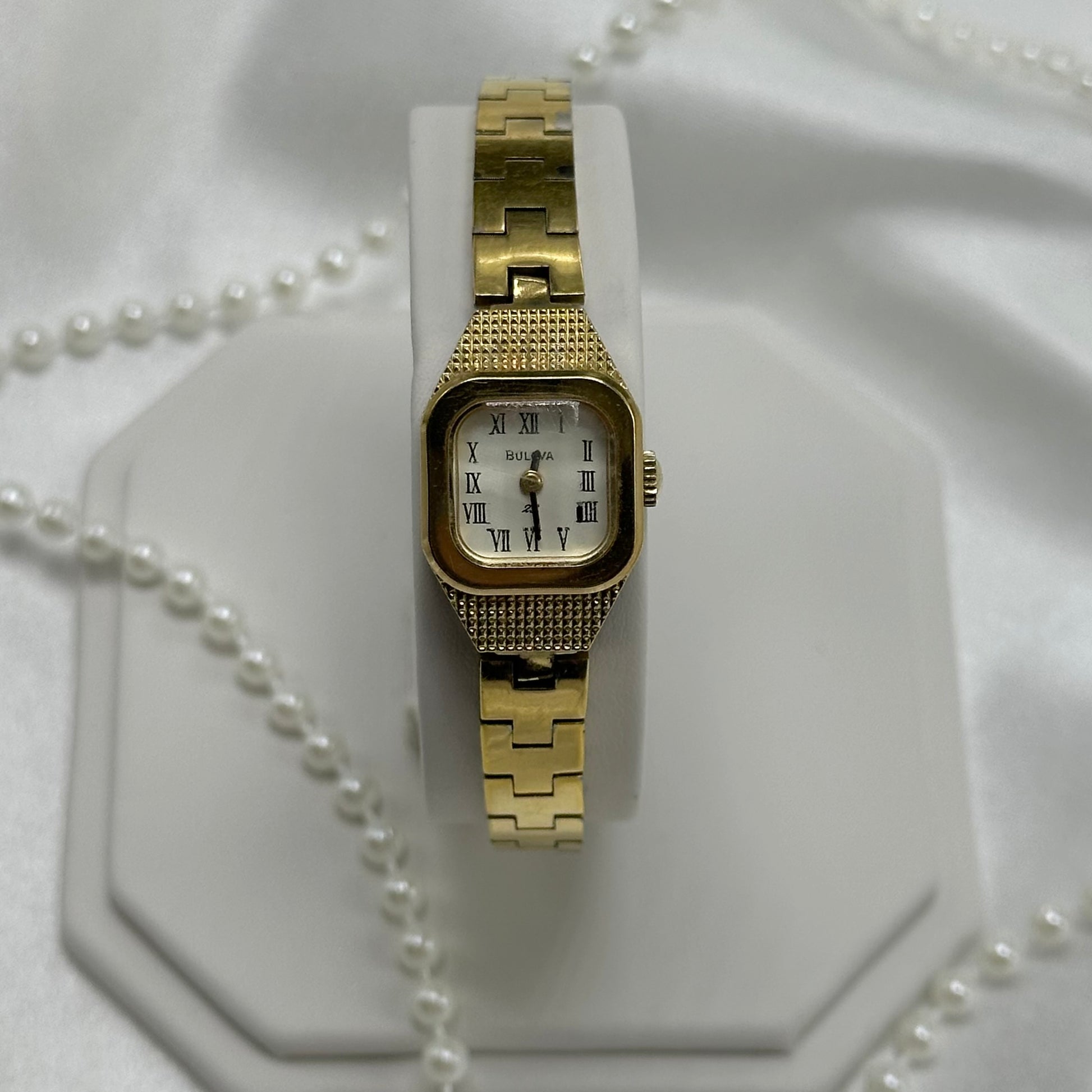 Vintage Bulova 23 Jewels manual winding watch with clasp band and faceted crystal from 1976.