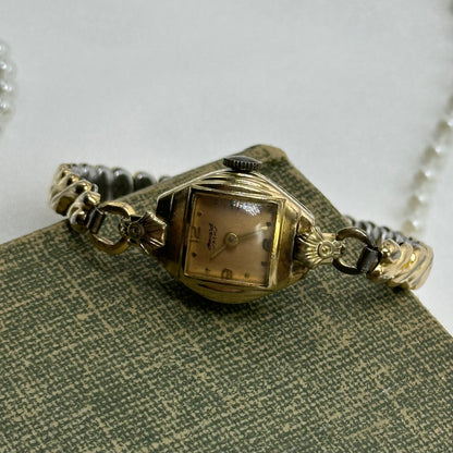 Vintage Howard ACH 10k rolled gold-plated manual winding watch with stretchable band and rose gold dial.