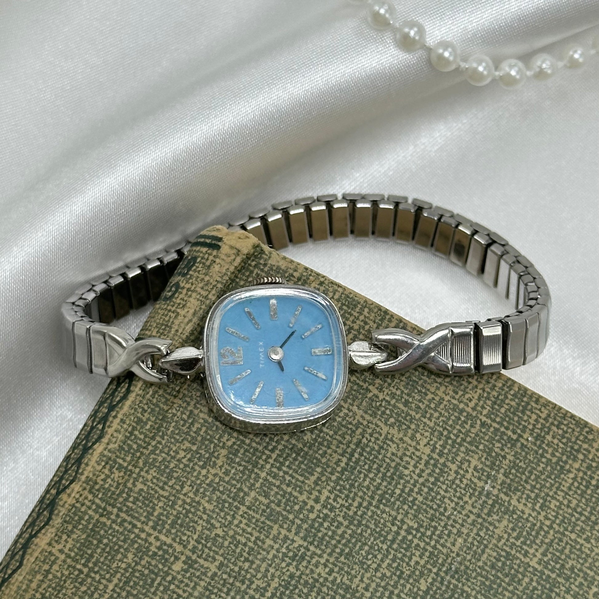 Vintage blue dial Timex manual winding watch with stretchable band.
