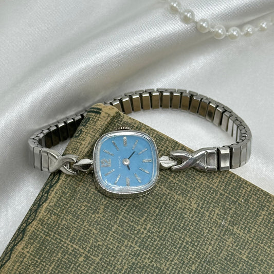Vintage blue dial Timex manual winding watch with stretchable band.