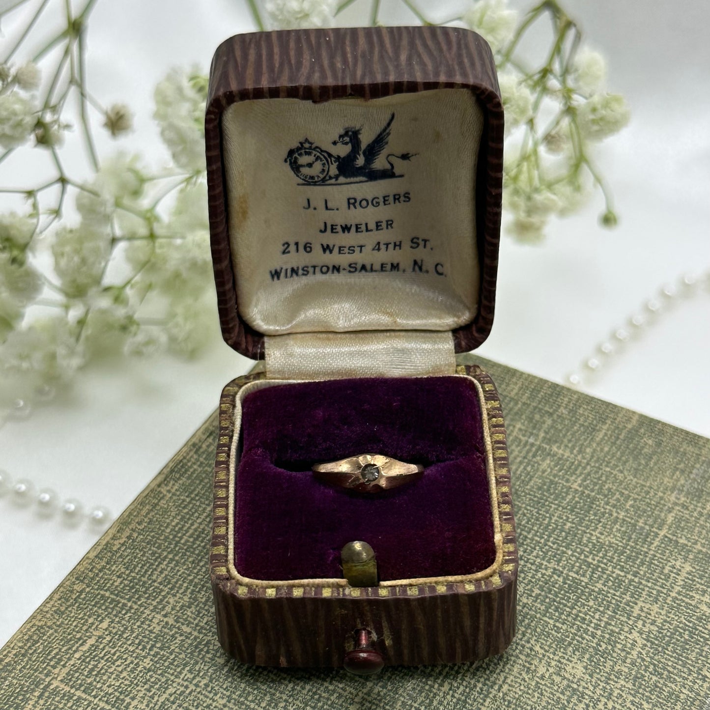 Vintage bronze tone baby ring with small stone and original ring box.