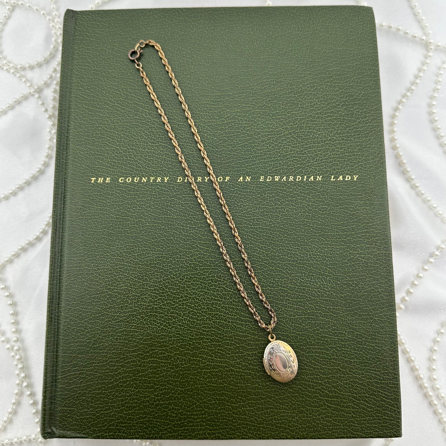 Vintage dainty locket with engraved floral design.