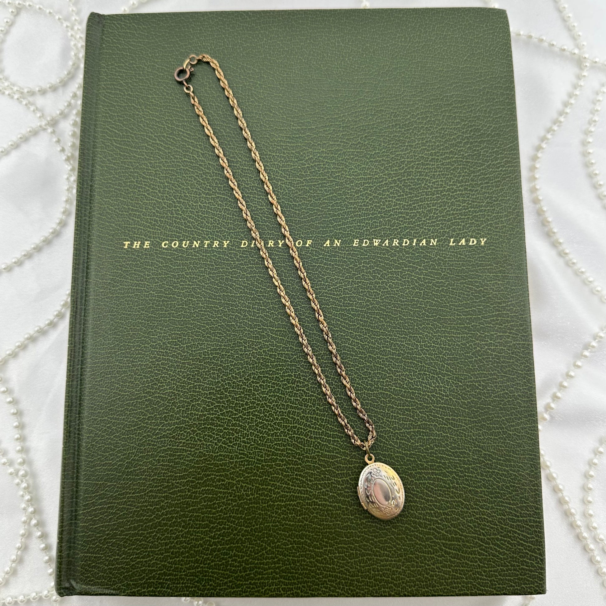 Vintage dainty locket with engraved floral design.