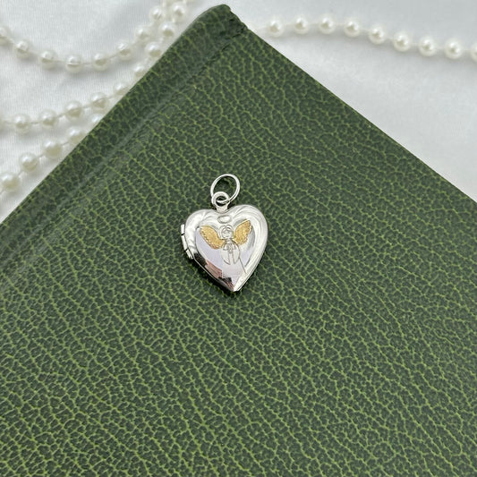 Vintage dainty silver heart locket with gold winged angel engraved. Marked Sterling.